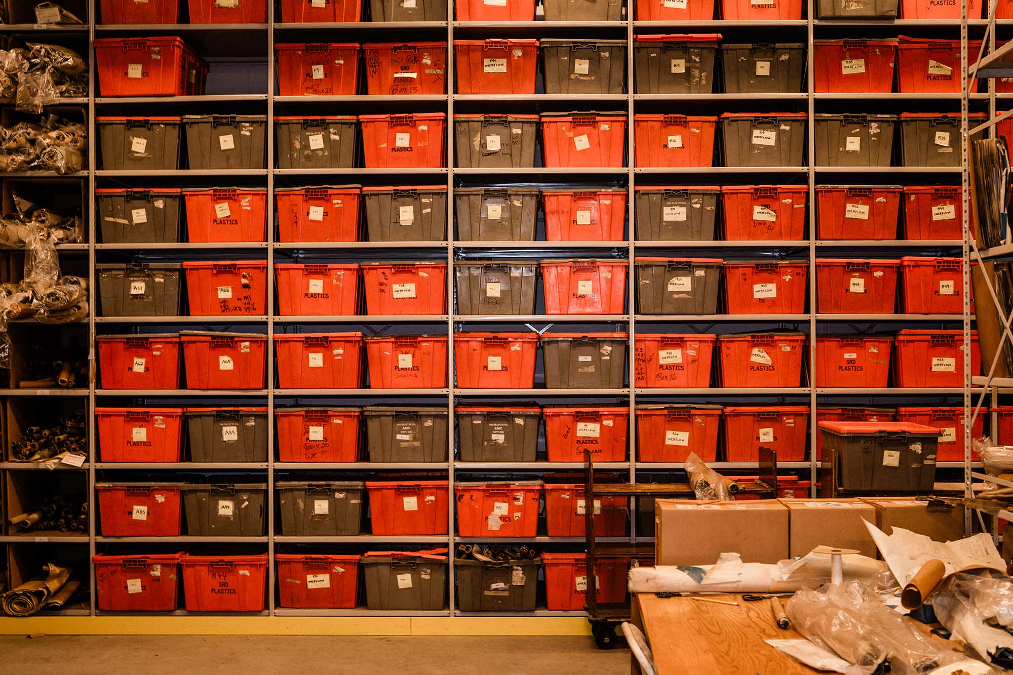 Photo: A large storage room wall is shown containing large red and black containers.