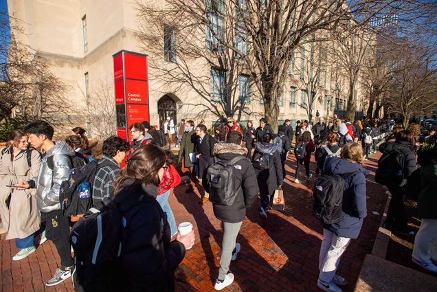 Photo: A crowd of students mingle and commute to their classes on Bu's campus. Various different coats and backups adorn them.