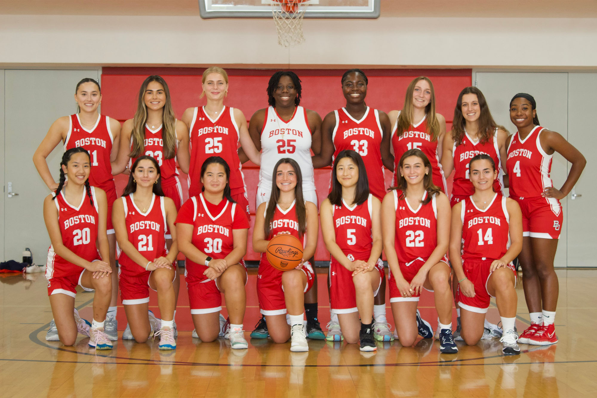 Photo: The BU Women's club basketball team, in bright red and white jerseys with their coaches in normal clothes on the sides