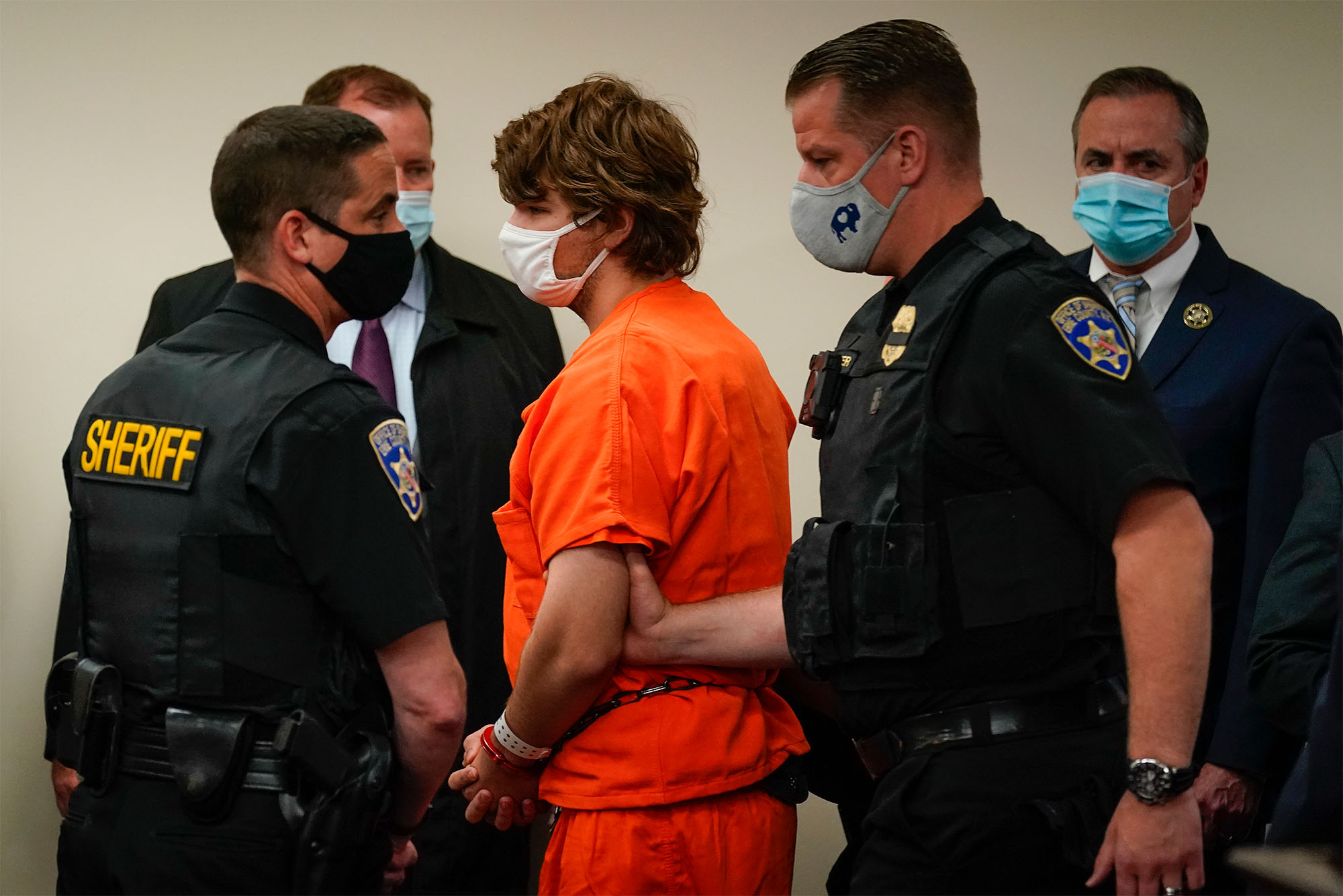 Photo: A Picture of police around a man in an orange jumpsuit