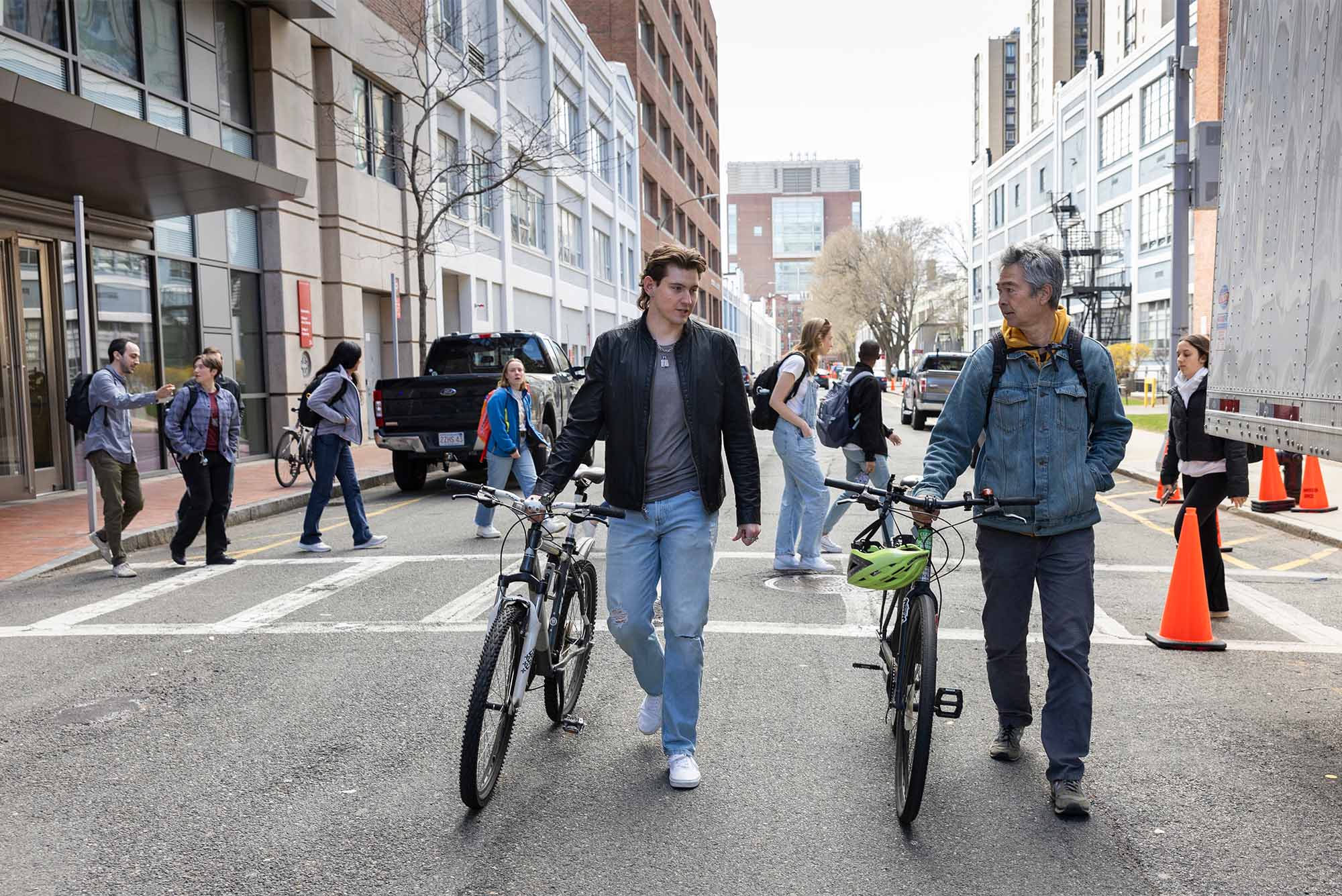 Photo: Two college students with bicycles walk down a busy pedestrian avenue in Boston, MA
