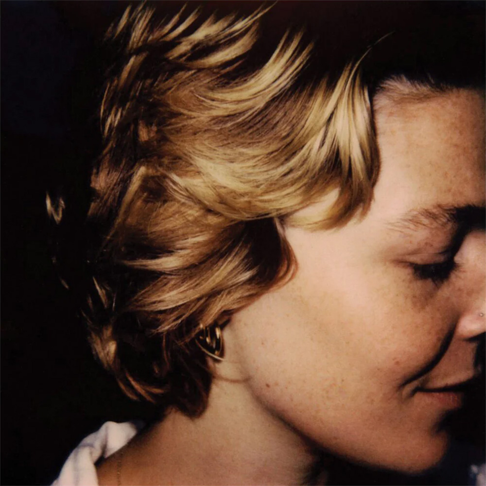 Photo: A album cover of a portrait of Maggie Rogers, a white woman singer. She has short blonde hair, the picture highlighting her right portrait.