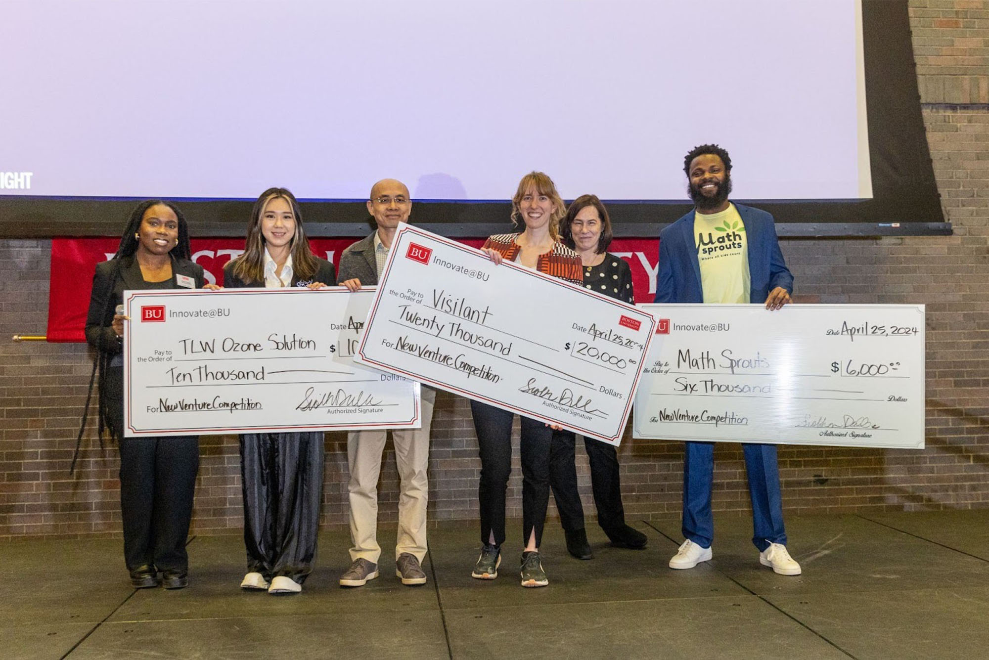 Photo: A group of students holding large checks at a recent innovation competition at Boston University
