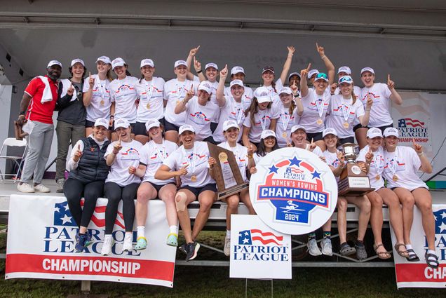 Photo: A picture of the BU Women's Rowing team smiling and posing around a sign that says "Women's Rowing Champions 2024"