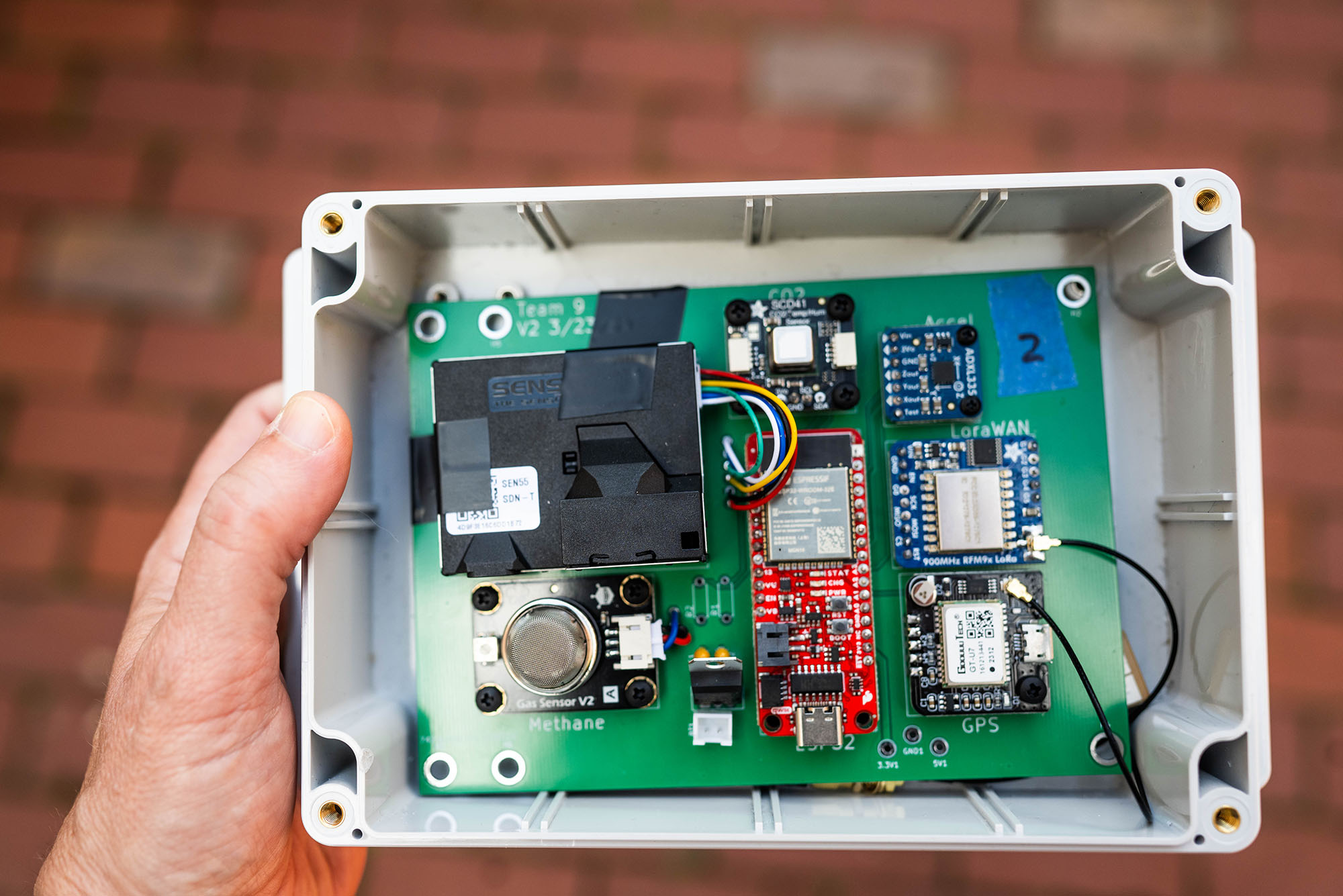 Photo: A hand holding a large box full of circuit boards and sensors