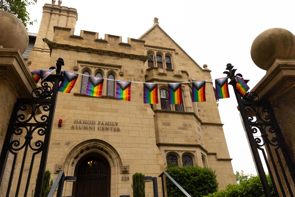 Photo: A picture of the Dahod Family Alumni Center, a gothic-style building with stained glass windows, with pride flags strung outside of its gates