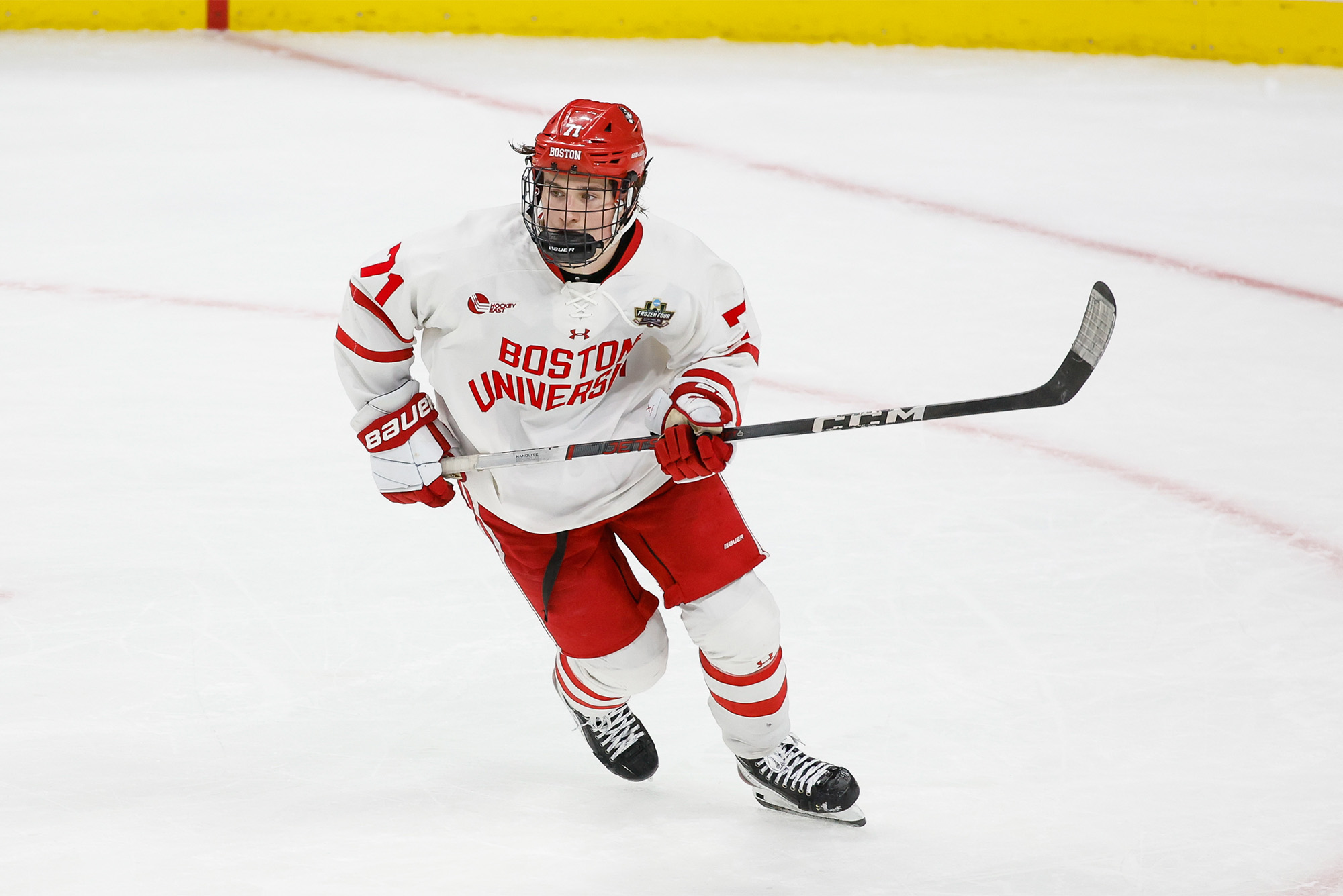 Photo: Macklin Celebrini, in a red BU hockey jersey, skating during a BU men's hockey game