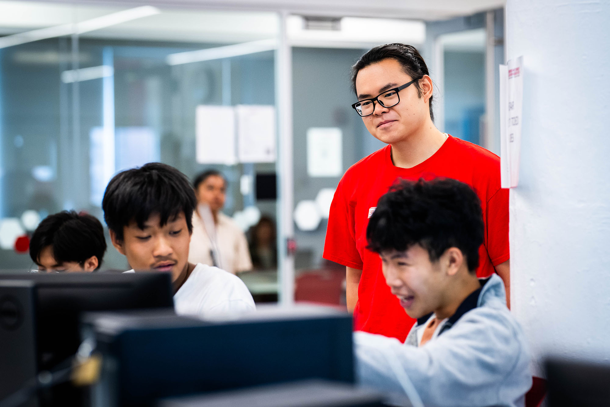 Photo: A picture of three people engaging with a computer screen. They appear amused and intrigued by what is on the screen