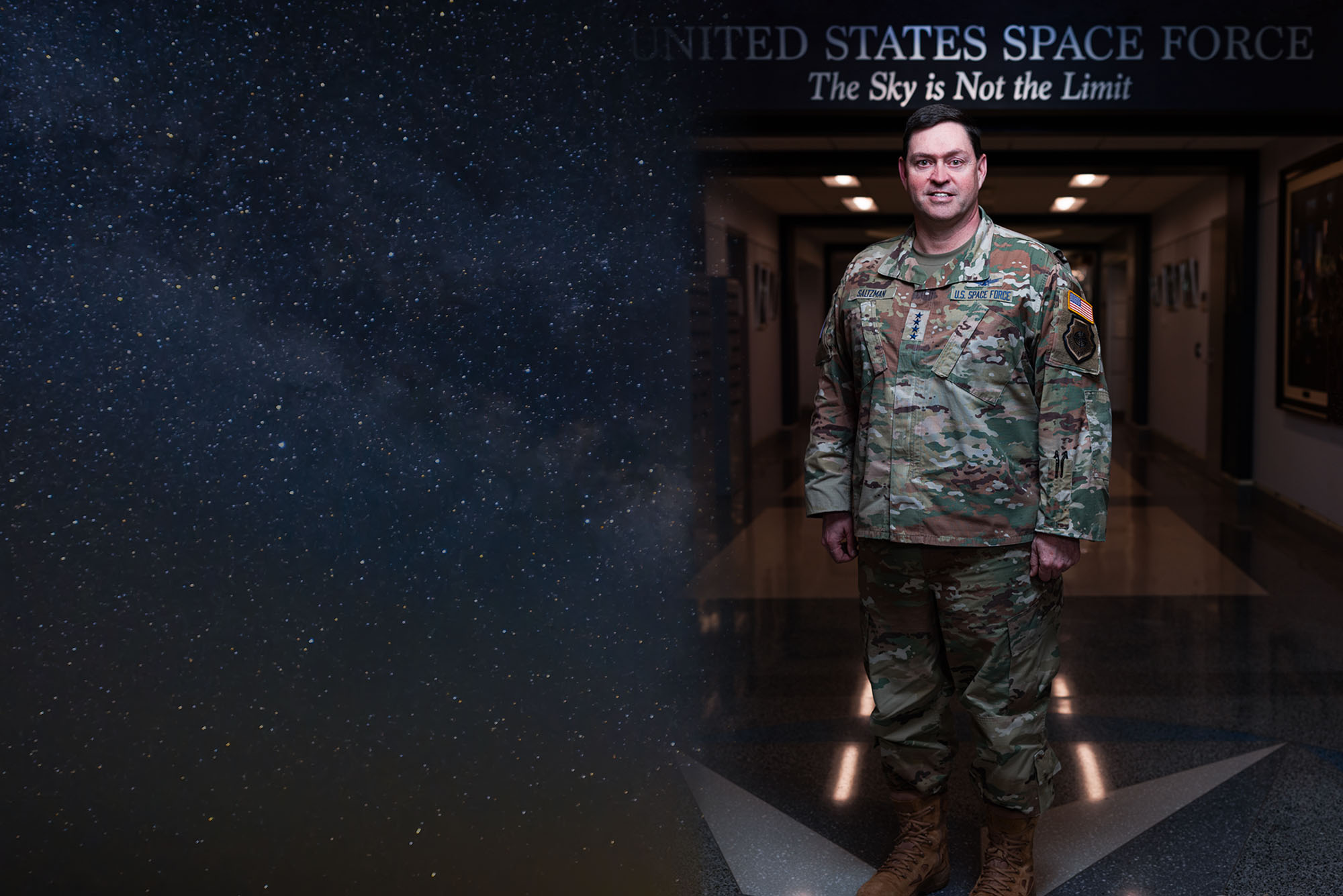 Photo: A man in a military outfit with badges and stars indicating he is a General in the US Space Force. The Banner above his head reads "United States Space Force. The Sky is Not The Limit"