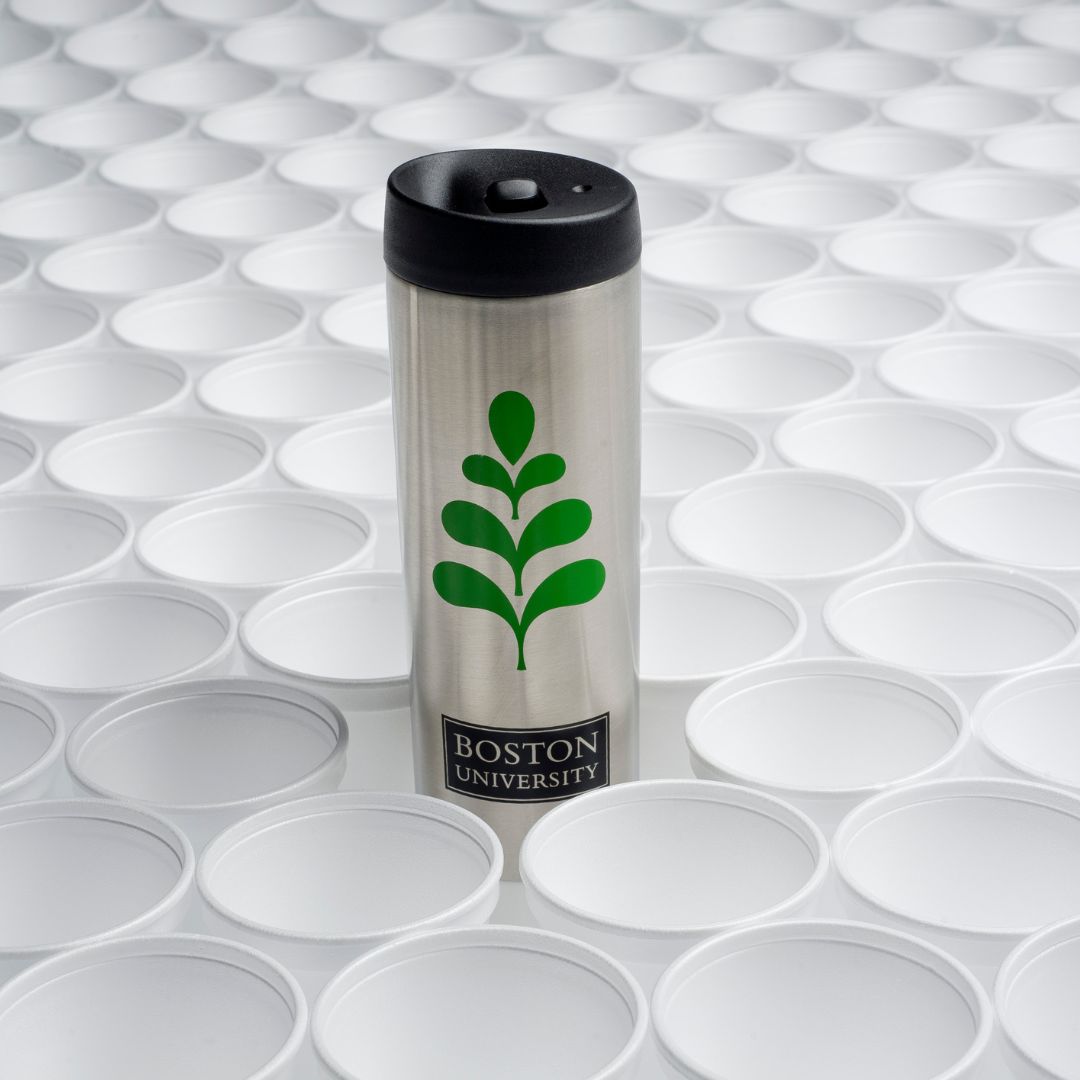 Photo: A reusable Boston University Sustainability branded water or coffee bottle sitting above multiple white plastic cups.