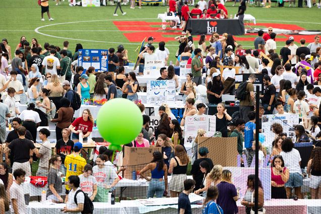 Photo: A large group of college students gathered on a football field on a sunny day for an event about student activities and clubs