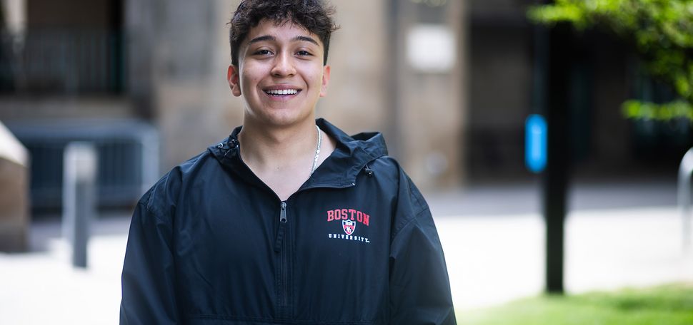 Photo: A picture of a young man wearing a black Boston University windbreaker, with the university's logo at the top left in a red font.