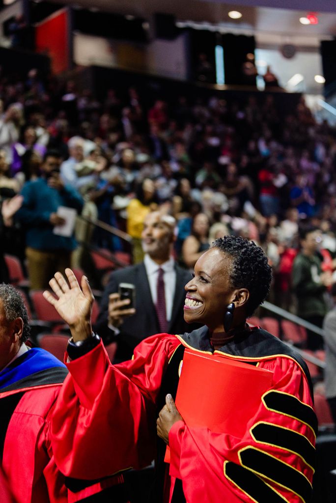 Photo: Melissa L. Gilliam waves to the people in the crowd wearing her ceremonial robes.