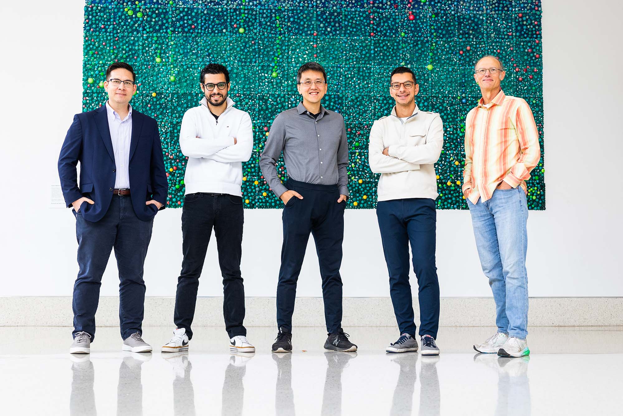 Photo: A group of men standing side by side in an open area, smiling for the camera.