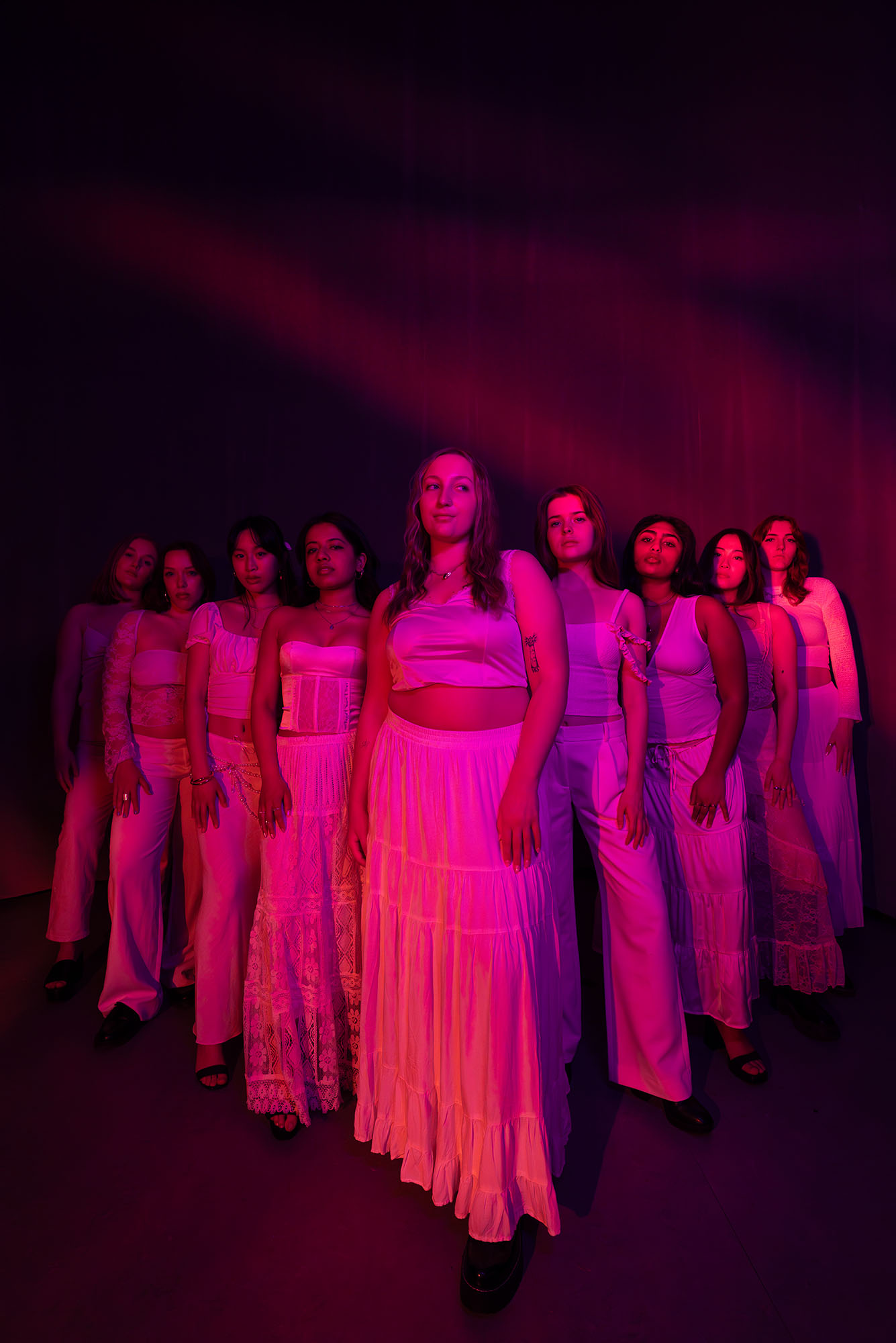 Photo: BU's Trebelmakers pose in a V-formation under pink, artistic lighting.