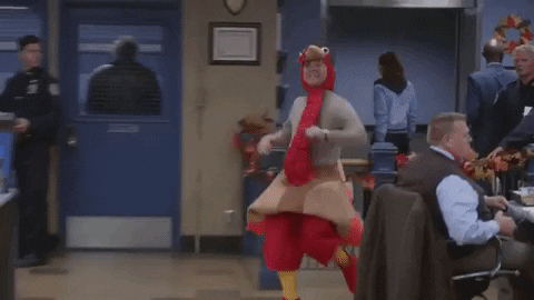 A clip from Brooklyn nine-nine's Thanksgiving episode, with a man prancing around a busy police station in a turkey costume.