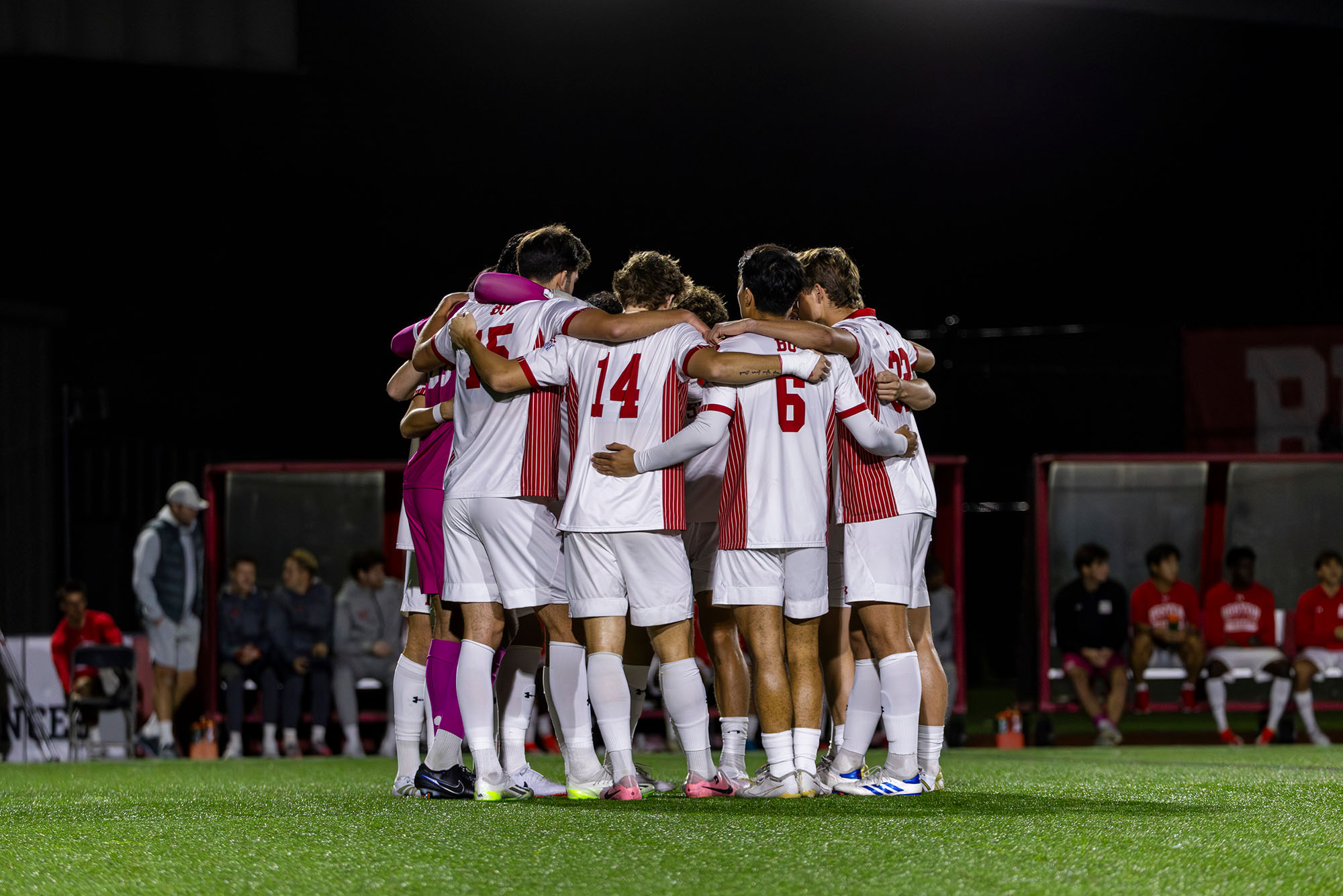 Photo: A picture of a soccer team in red and white uniforms huddling on a field
