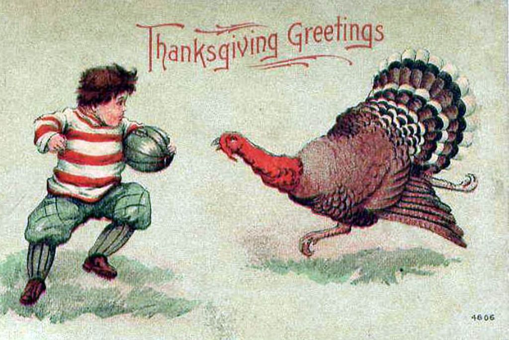 Photo: A postcard from the 1900s featuring a little boy holding a football and a wild turkey. Text says "Thanksgiving Greetings"