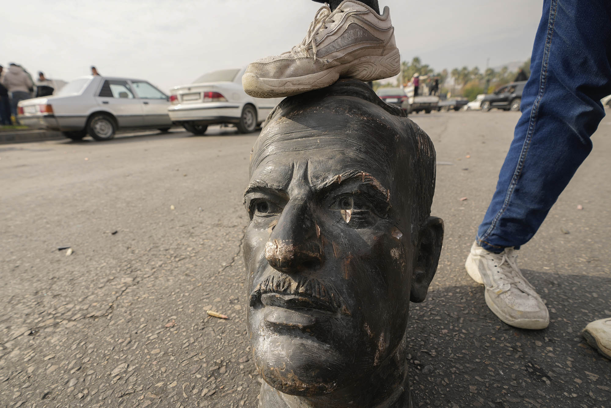 Photo: A statue of late dictator Hafez Assad stepped on by a Syrian rebellion leader.