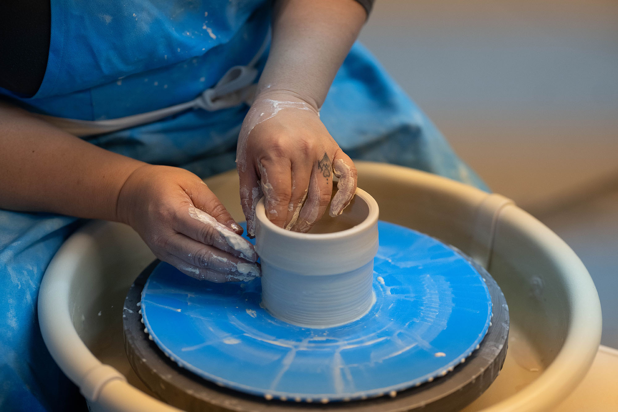 Photo: Hands molding clay on a potter's wheel.