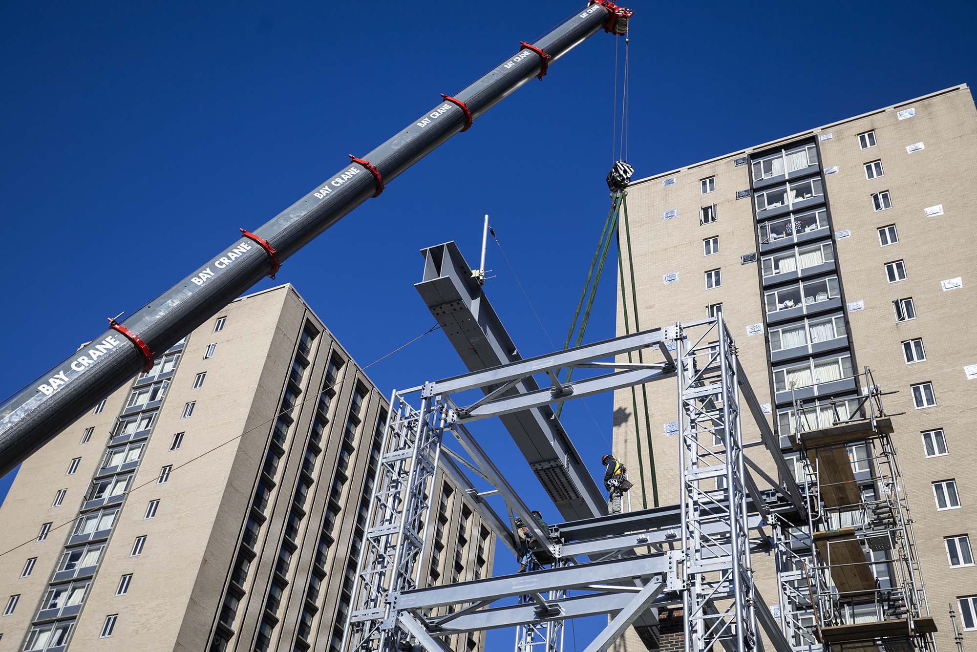 As part of the ongoing Warren Towers renovation, a crane preps the building with steel beams for its renovation process.