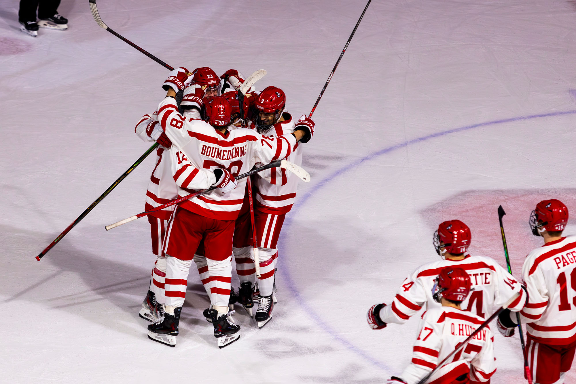 Photo: A gorup of Boston University hockey plays hugging on the ice