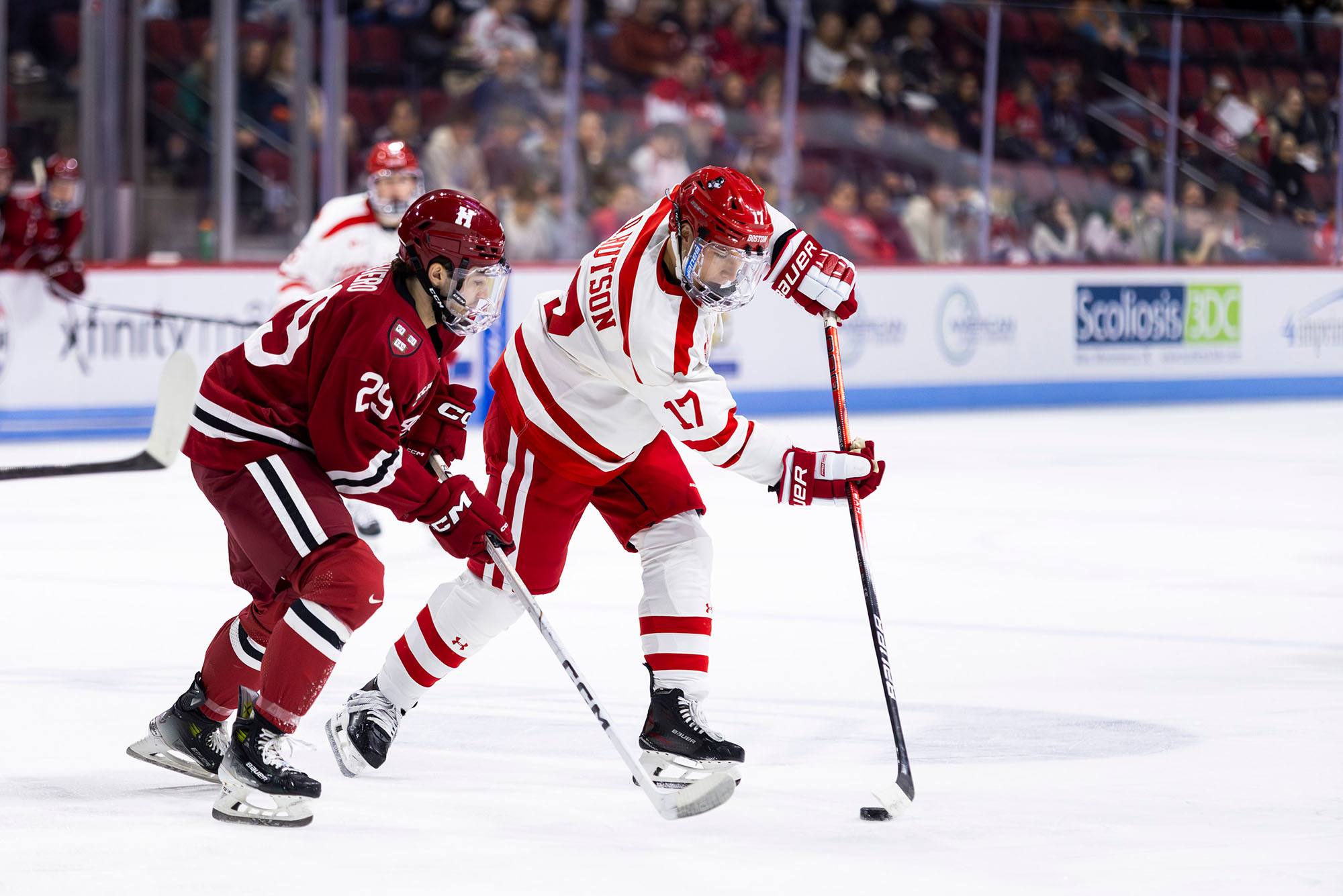 Photo: Two hockey players on the ice, with the Boston University one in possession of the puck