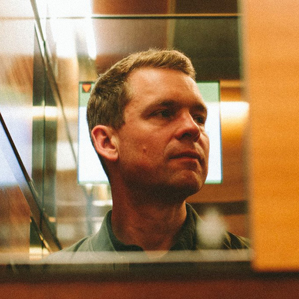Photo: a white man with short hair poses for a portrait 