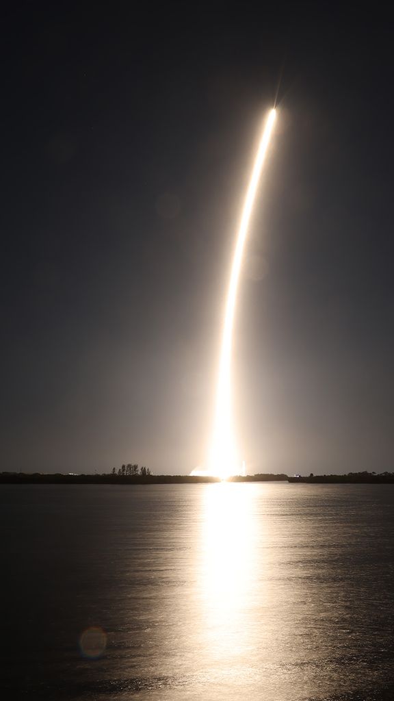 Photo: A rocket blasting off into space over the water.