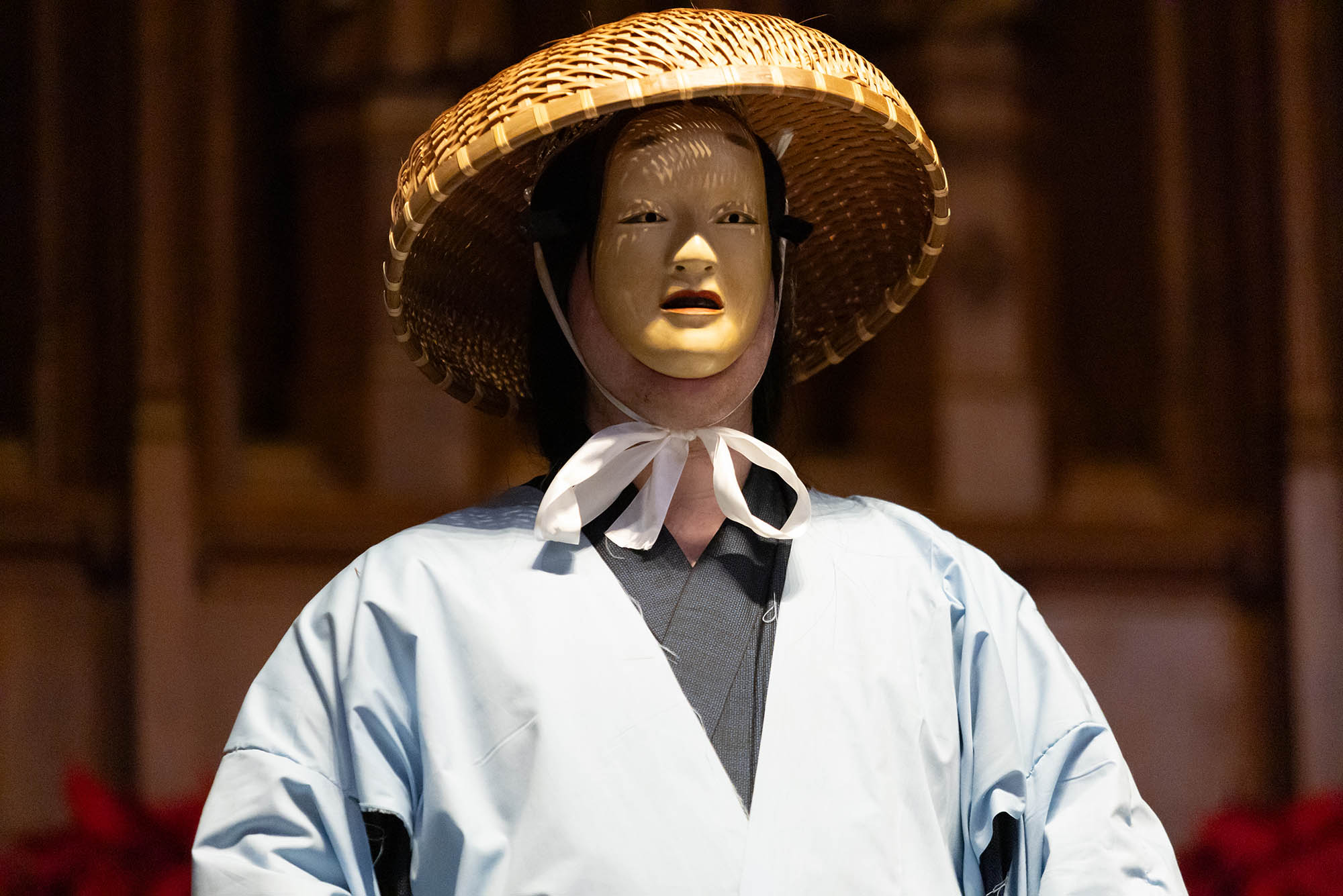 Photo: A individual with a small mask on and a wicker hat with a light blue kimono.