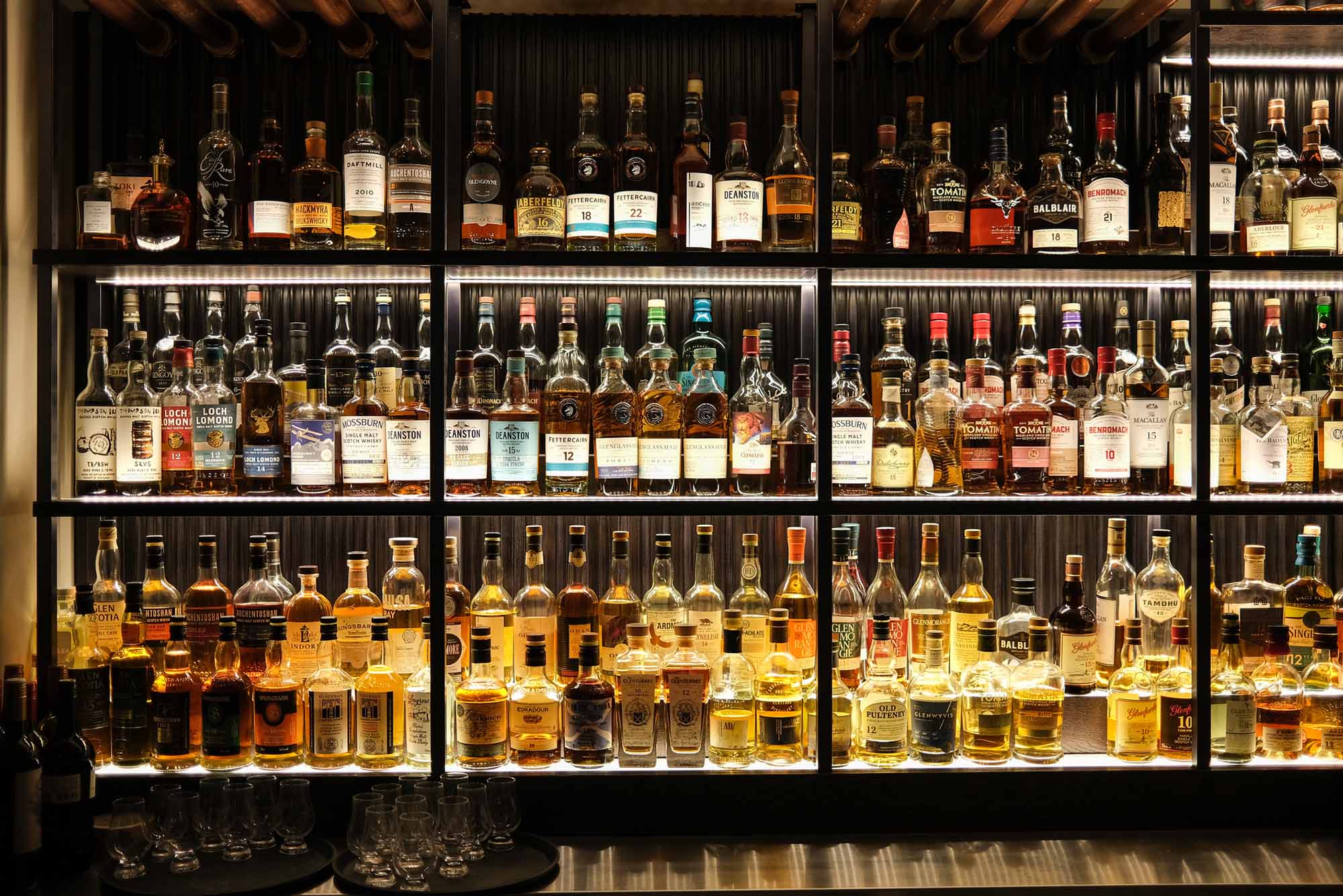 Photo: A stock photo of various whiskey bottles on shelves in a bar.