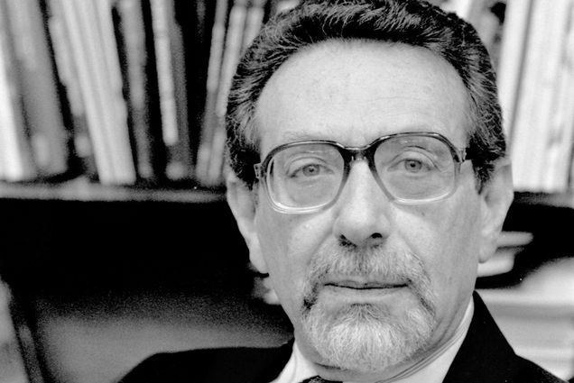 Photo: Black and white photo of a man wearing a suit and glasses
