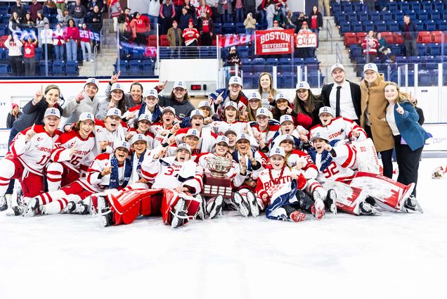 Photo: BU Women's Hockey team holding their trophy after winning the Hockey East Tournament