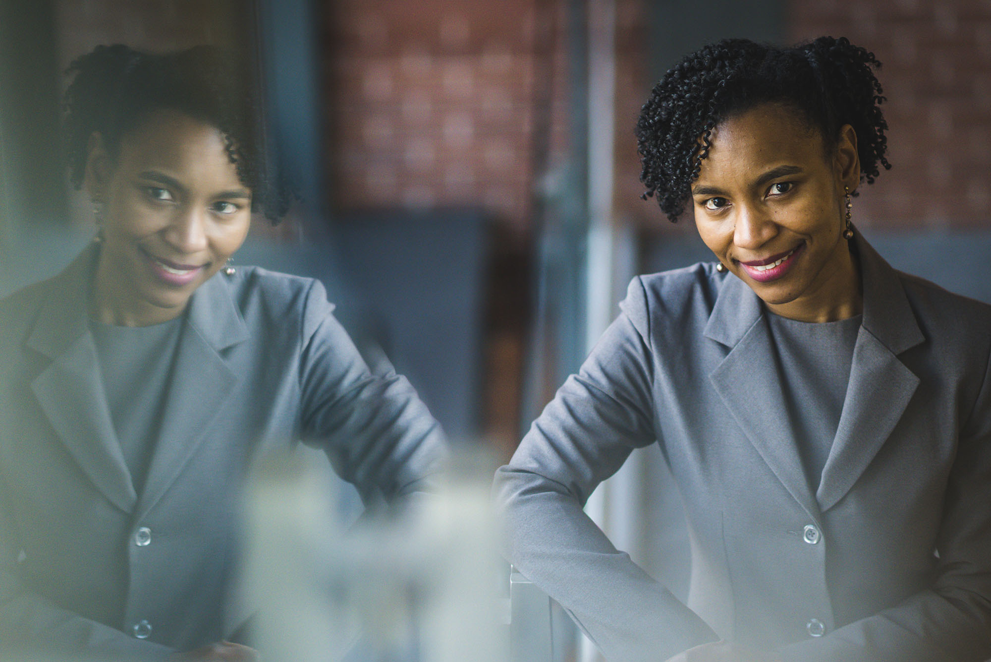 Photo: A woman in a gray suit with curly dark hair poses for a formal portrait