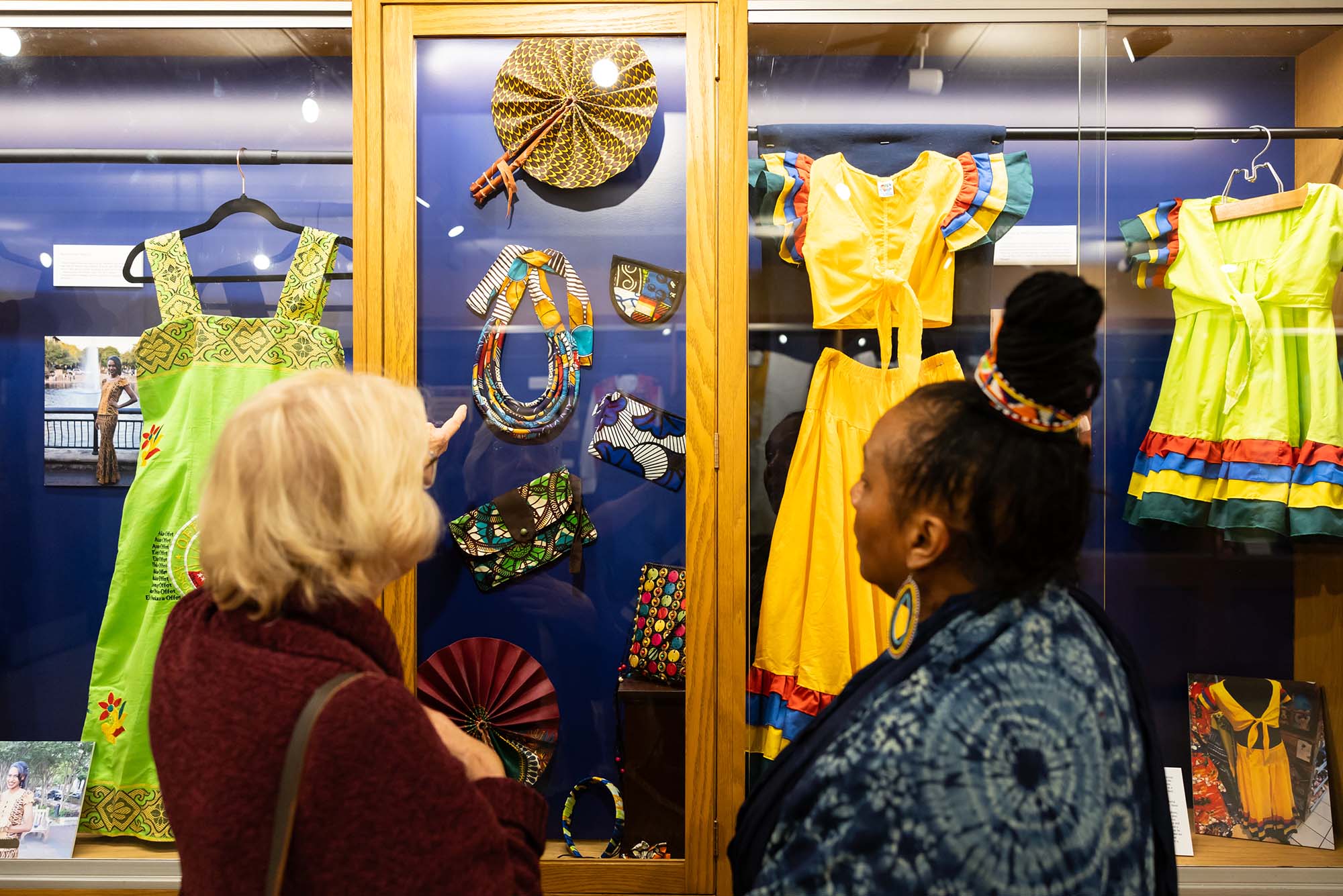 Photo: Two individuals observe an exhibition on African Textiles.