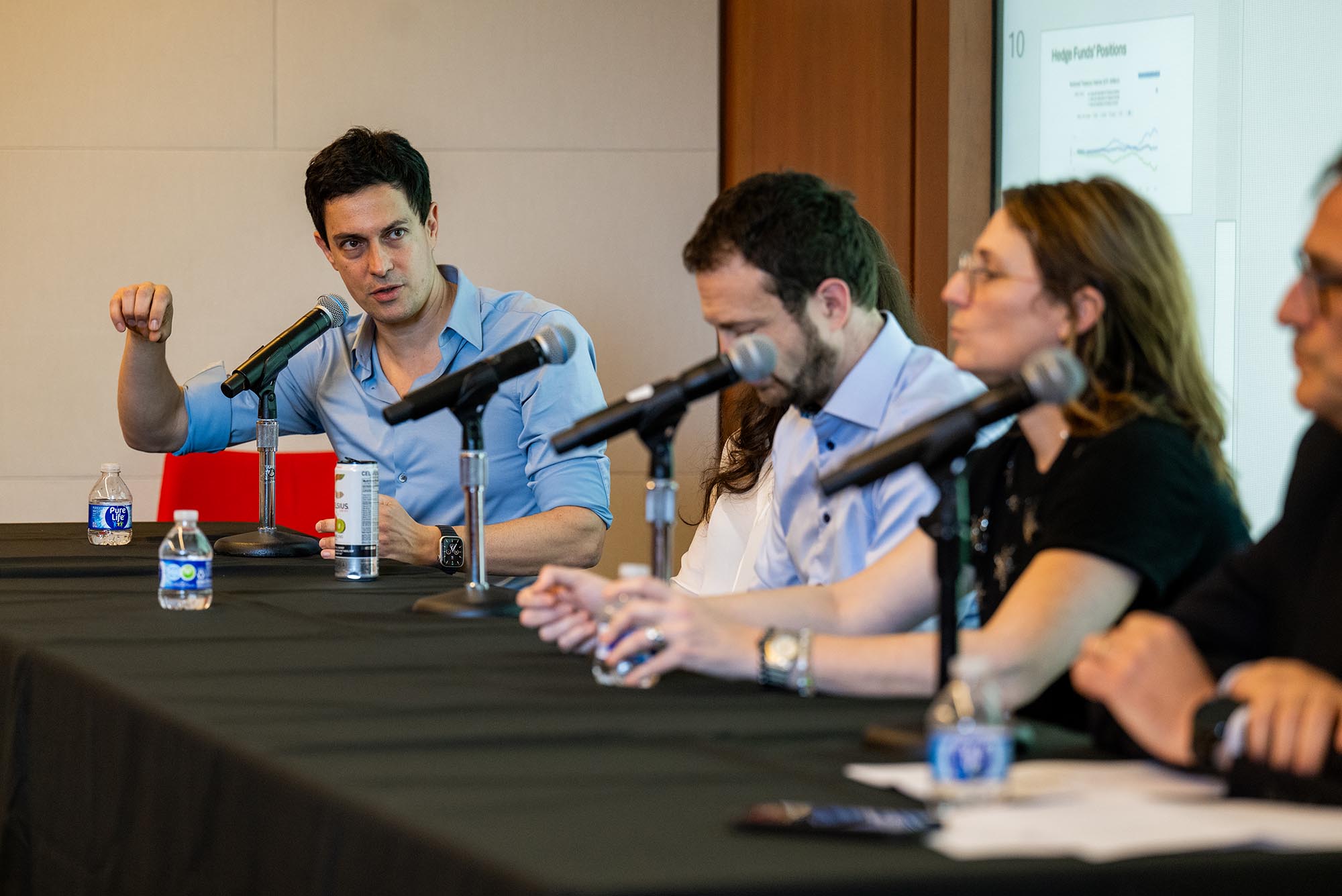 Photo: A man talking in a mic at a panel with other individuals.