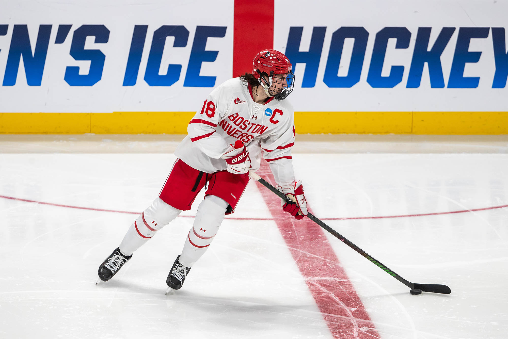 Photo: A young white man skating on the ice with a BU hockey team.