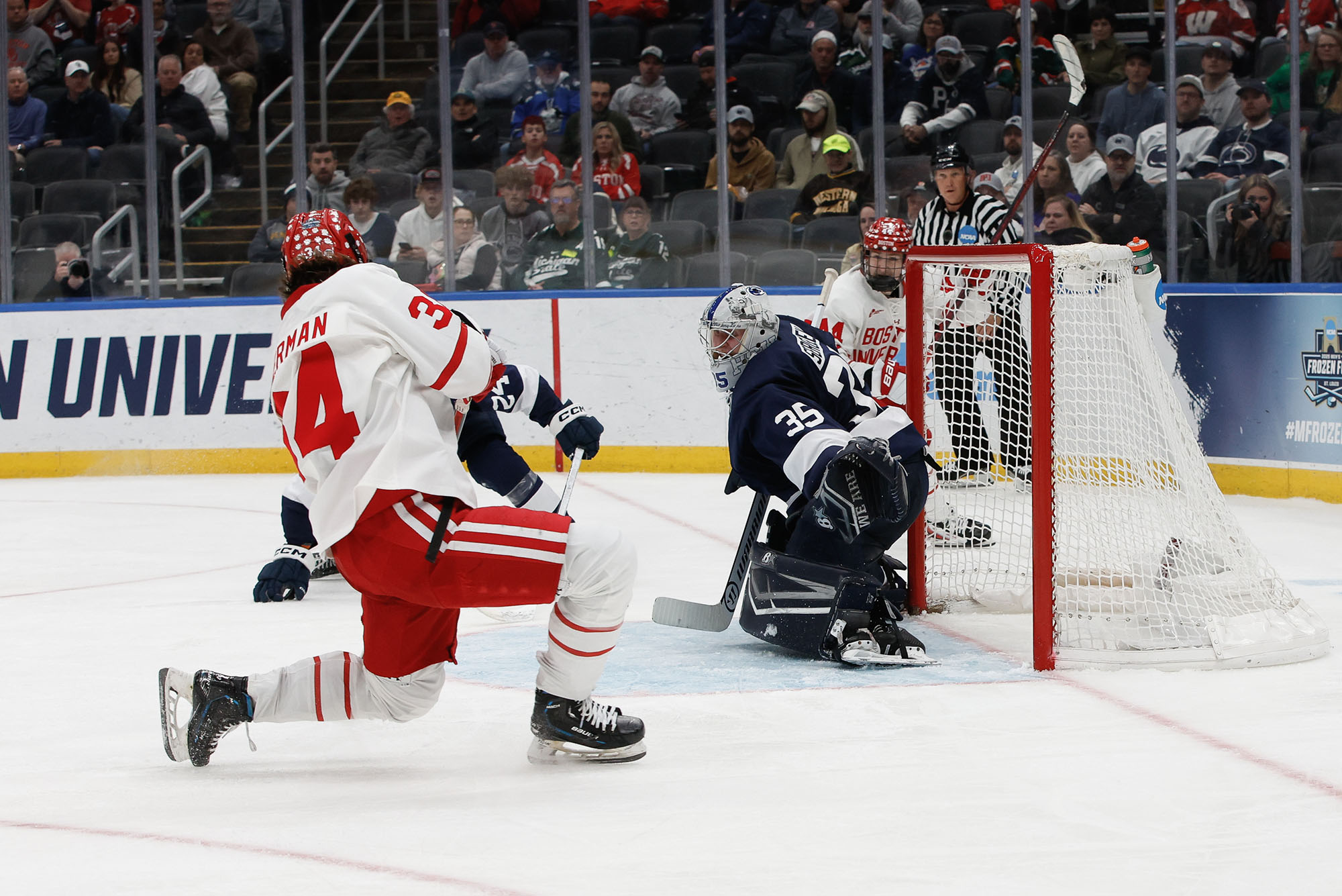 Photo: BU men's hockey player #34 kneeling on the ice after scoring a goal