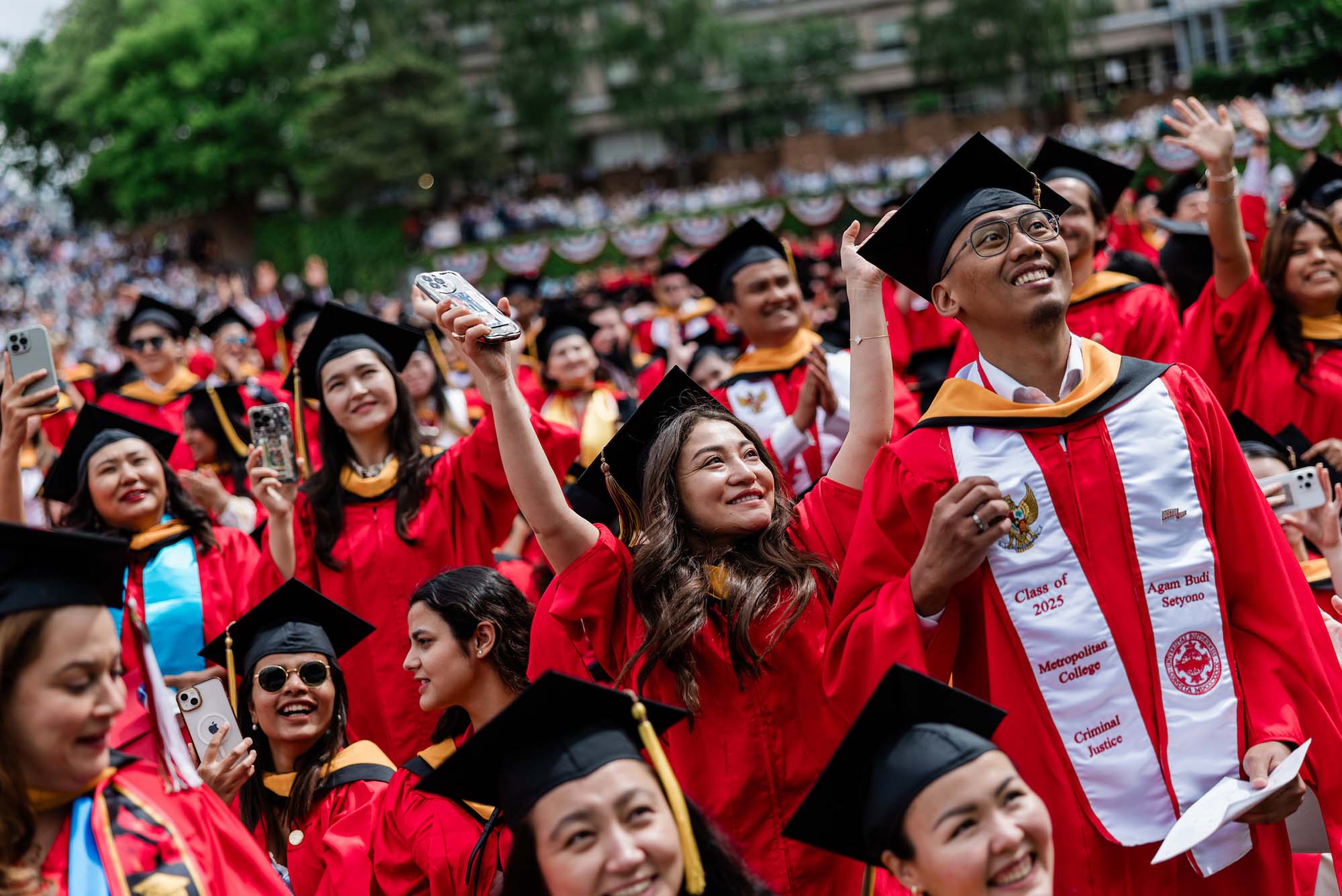 Photo: College students in red robes and caps celebrate at 波士顿大学s 152nd commencement in 2025