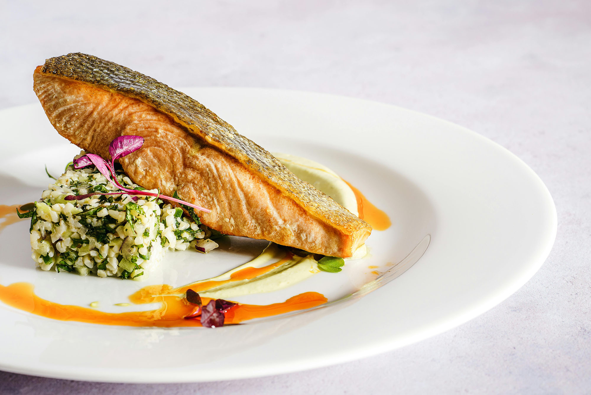 Photo: A piece of salmon plated with a side on a white plate