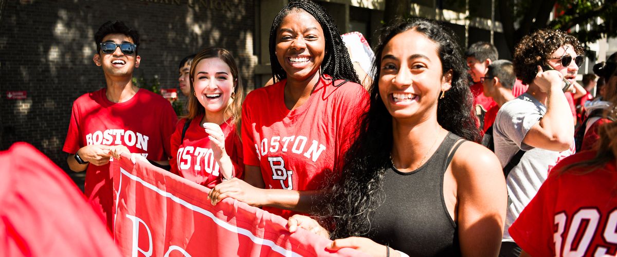 Students smiling holding BU banner