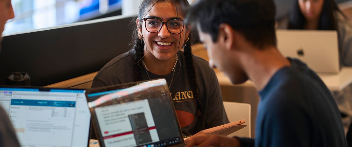 Students on laptops in the CDS
