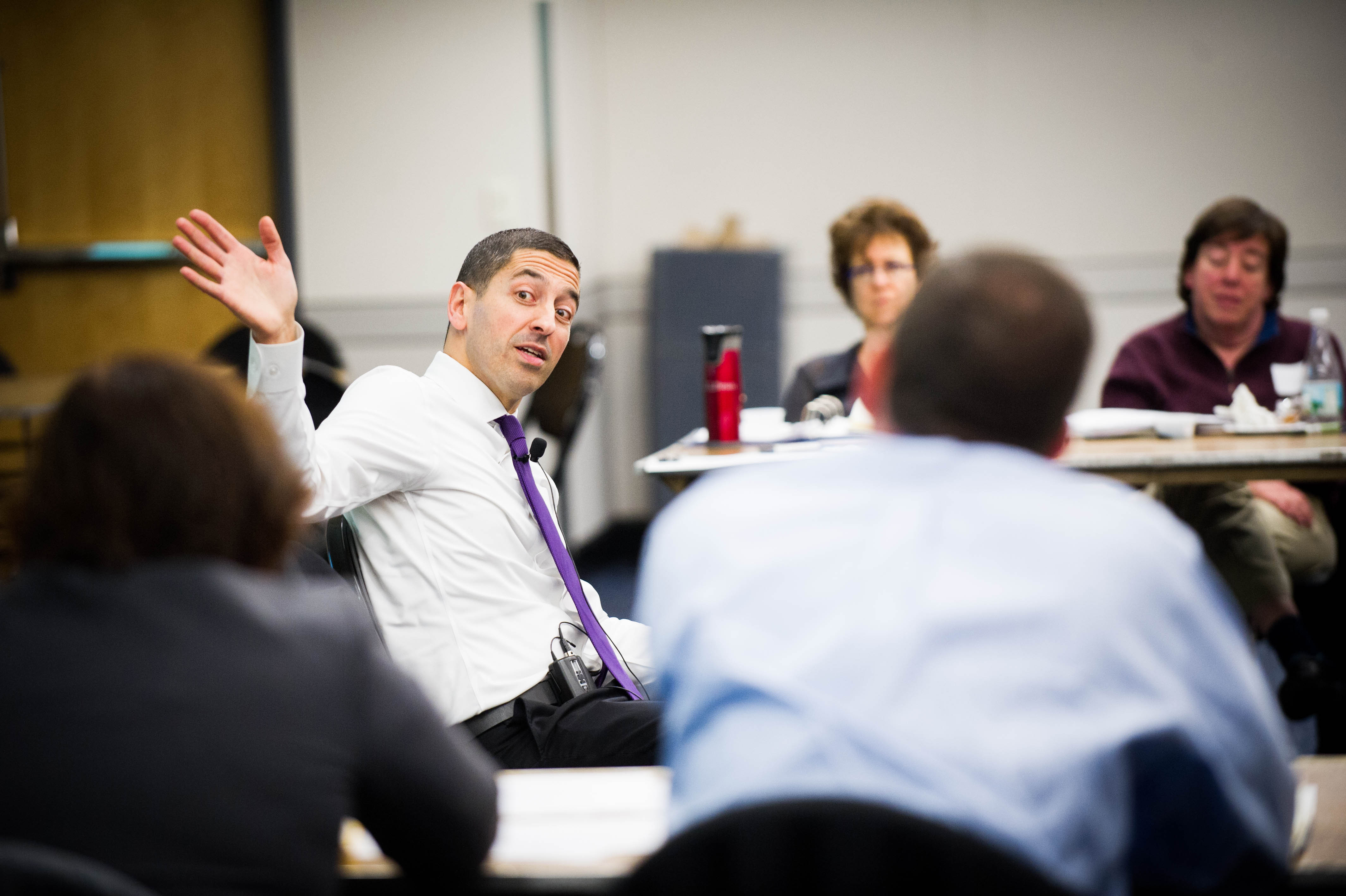 A faculty member runs a meeting in a classroom setting.