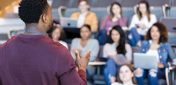 Male professor lecturing to a group of students