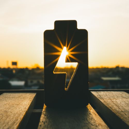 Sunlight shining through energy symbol on a battery