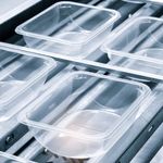 Plastic containers on a conveyer belt.