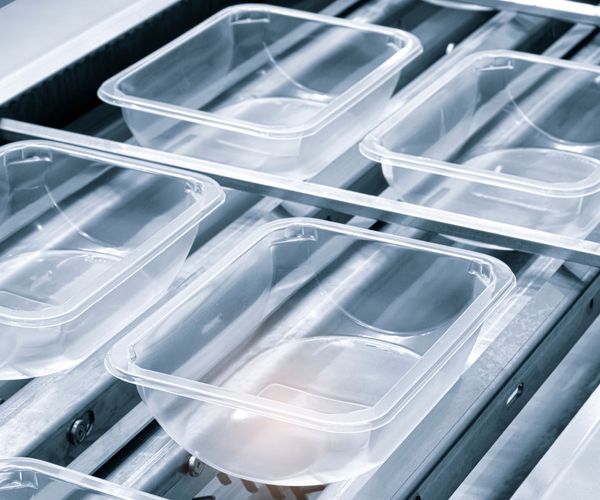 Plastic containers on a conveyer belt.