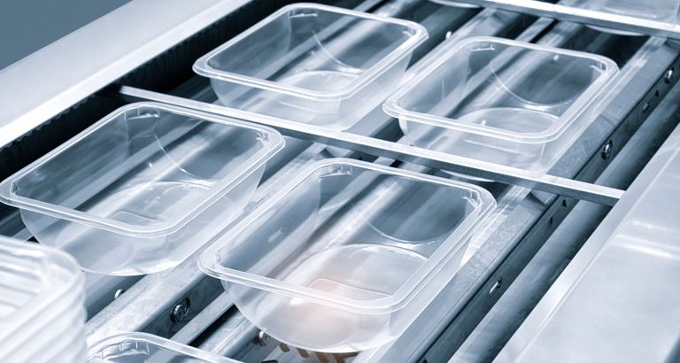 Plastic containers on a conveyer belt.