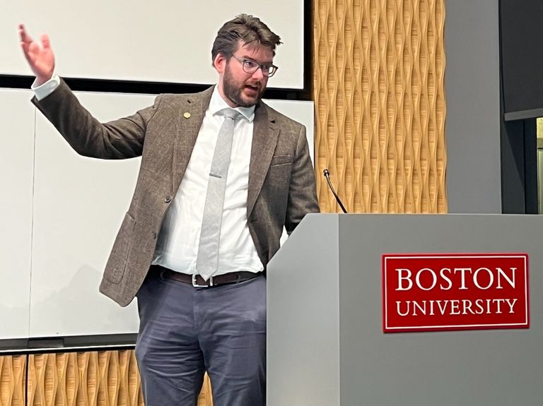 A professional giving a lecture at a Boston University podium.
