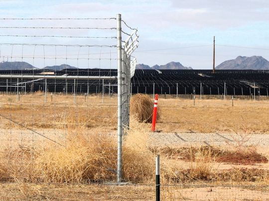 Fence and solar panels in an arid environment.